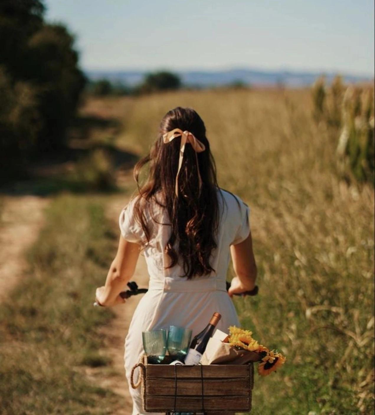 Femme transportant une bouteille de vin dans son vélo