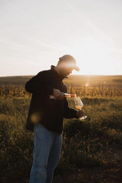 Vigneron dans les vignes dégustant un verre de vin - caviste en ligne